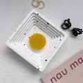 Macro view of bright yellow circular phone grip on a stylish white textured tray - Turmeric