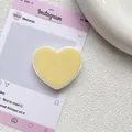 Vue détaillée d'un support de téléphone en forme de cœur au style minimaliste jaune pastel - Jaune Lait