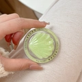 Macro shot of light green glitter shell phone grip with Magsafe magnetic base in hand - Glitter Jelly Seashell / Fruit Green