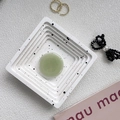 Macro detail of a pale green round jade phone socket on a stylish textured tray - Matcha Green