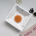 Top view of a square terrazzo tray with black ink splatters and a centered orange round piece - Morandi Orange