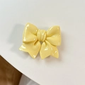 Close-up of yellow bow retractable phone grip with a glossy resin finish and 3D folds - Yellow
