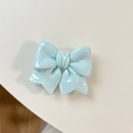 Close-up of glossy sky blue bow phone grip with high shine finish on white background - Blue