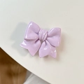 Close-up of glossy purple bow phone grip with a polished resin finish on white backdrop - Purple
