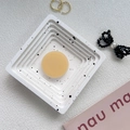 Flat lay of a round solid perfume on a white speckled tray with elegant lifestyle props - Autumn Orange