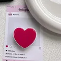 Vue macro détaillée du support de téléphone en forme de cœur rose foncé avec finition brillante - Rouge