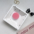 Close-up of a pink round phone grip on an artistic white tray with black marble patterns - Coral Pink