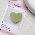 Gros plan d'un support de téléphone en résine en forme de cœur vert clair poli - Vert matcha
