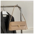 Detail of beige baguette bag with gold buckle styled on a grey blazer and metal hanger - Khaki