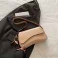 Glossy apricot saddle bag with cherry charm on a grey blazer, minimalist chic style - Khaki with Pendant