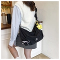 Detail of a black nylon hobo bag with drawstring bow and yellow daisy floral charm - Black (With Flower Charm)