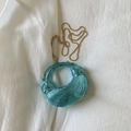 Detail of light blue metallic mini bag with ribbed texture, knot accents and gold chain - Blue