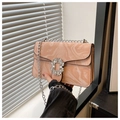 Détail d'un sac à main rose clair à motif marbré avec boucle cristal et chaîne argent - Rose
