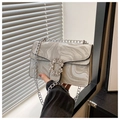 Detail view of marble texture crossbody bag with sparkling rhinestone buckle and silver chain - Silver