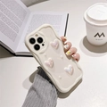 Detail of cream wave-textured iPhone case with pearl heart charms in a lifestyle setting - iPhone 7/8/SE 2020 / Holographic Crooked Heart (Cream White)