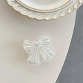 Detailed macro view of an iridescent bow phone grip with heart center and pearly finish - Pearlescent White