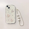 Detail of white wavy phone case with 3D hearts and matching pearl wrist strap - iPhone 7/8/SE 2020 / Holographic Pleated Heart + Pearl Bracelet (Cream White)