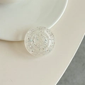 Detail of round glitter phone grip with silver sequins on a cream-colored desk - Clear