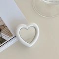 Close-up of white heart-shaped folding phone grip with high-reflection mirror surface - White