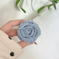 Vista macro di una rosa in tessuto azzurro con bordi sfrangiati per supporto telefono - Blu (Supporto Trasparente - Rosa Arrotolata)