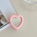 Close-up of pink heart-shaped expandable phone socket with mirror on a soft background - Pink
