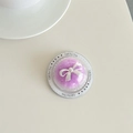 Macro detail of clear dome phone grip with purple plush base and white bow decoration - Purple