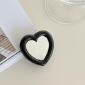 Macro detail of heart-shaped phone grip with integrated mirror and sleek black border - Black