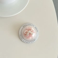 Dettaglio del supporto per telefono trasparente con peluche rosa e confezione fiocco argento - Rosa