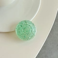 Primer plano de un soporte para teléfono verde menta con lentejuelas brillantes - verde oscuro