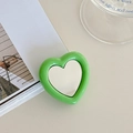 Macro detail of a heart-shaped phone grip with a green finish and built-in mirror - Green