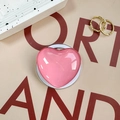 Close-up of pink heart-shaped retractable phone grip with glossy reflective mirror surface - Pink