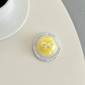 Vista macro del supporto per telefono rotondo con centro in peluche giallo e fiocco - Giallo
