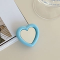 Detail of blue heart-shaped phone grip with a reflective mirror on a white desk - Light Blue
