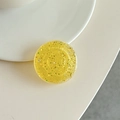 Close-up of a yellow glitter phone grip with colorful sequins and a resin finish - Transparent Yellow