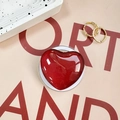 Close-up of a glossy red heart phone grip with glitter finish on a decorative tray - Burgundy