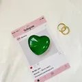 Vista macro del ciondolo in vetro verde a forma di cuore con anello dorato testurizzato - Verde Ciano