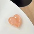 Dettaglio del supporto per telefono a cuore con glitter pesca e finitura perlata - Arancione Perlato