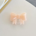 Macro detail of peach pink glitter bow phone grip with clear retractable base stand - Large Bowknot Stand - Pearlized - Orange
