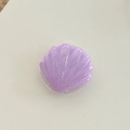 Macro detail of purple glitter shell phone grip with wave texture and transparent base - Purple