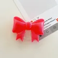 Close-up of a red glitter bow-shaped folding phone grip on a minimalist desk - Large Bowknot Stand - Pearlized - Red