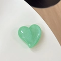 Vista macro del supporto per telefono a cuore verde con finitura in resina glitterata - Verde Frutta Perlato