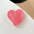 Close-up of heart-shaped glitter phone grip accessory with a polished pink finish - Pearlescent Red