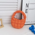Vibrant orange quilted puffer cloud handbag featuring a mini crescent shape and grid texture - Orange