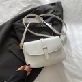 Minimalist white faux leather crossbody square bag with gold buckle on black suit background - White
