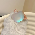Close-up of apple shaped phone grip with iridescent pearlescent finish and matte texture - Adhesive Holographic Apple Grip Tok