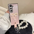 Detail of pink pleated leather phone case with pearl wrist strap and bow charm - Pink / Samsung ZFlip3