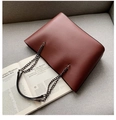Dettaglio della borsa tote in pelle bordeaux con tracolla a catena su sfondo di rivista - 44*13*26 / Marrone Rosso