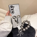 Detail of silver crinkled leather phone case with large metal bow and pearl bead strap - Silver / Samsung ZFlip3