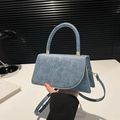 Minimalist trapezoid handbag in navy blue denim fabric with gold hardware and top handle - Blue