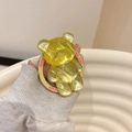 Close-up of a yellow jelly bear phone grip with Good Luck text on a wavy base - Water Ripple Bear (Magnetic) / Yellow